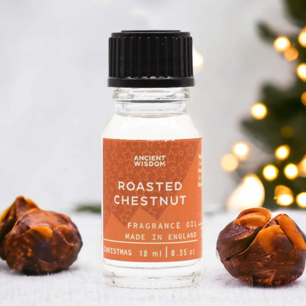Small 10ml bottle of roasted chestnut aromatic fragrance oil with amber liquid inside on white background