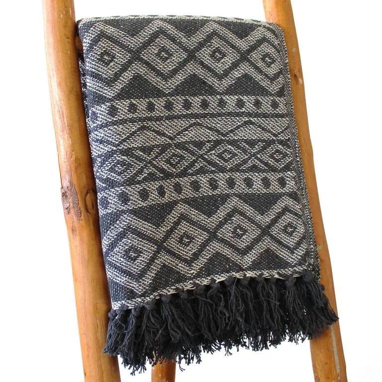 Grey geometric throw blanket laid flat, pattern visible on soft fabric