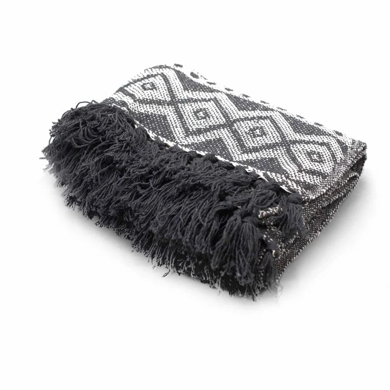 Grey geometric patterned boho comfort throw folded on a sofa, showing soft fabric texture