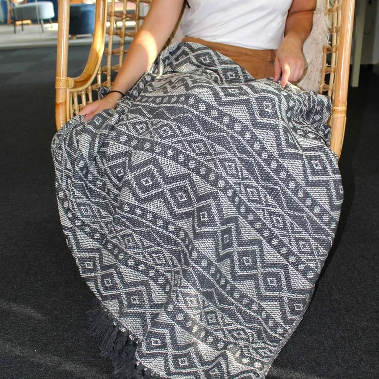 Grey boho blanket with geometric pattern, cozy texture.