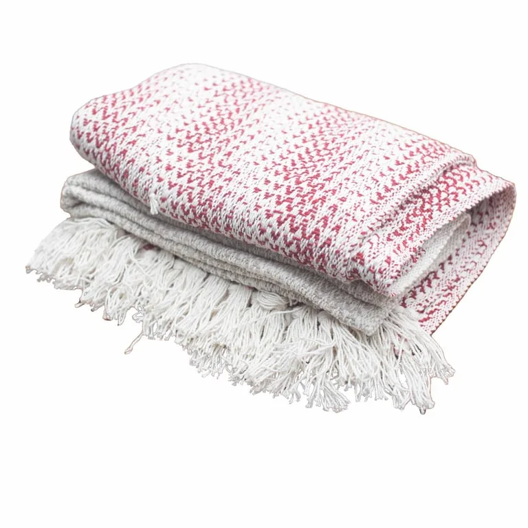 Two tone throws in ruby hues draped over a sofa, boho comfort style