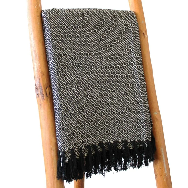 Fuzzy charcoal comfort throw with boho style pattern laid on neutral background