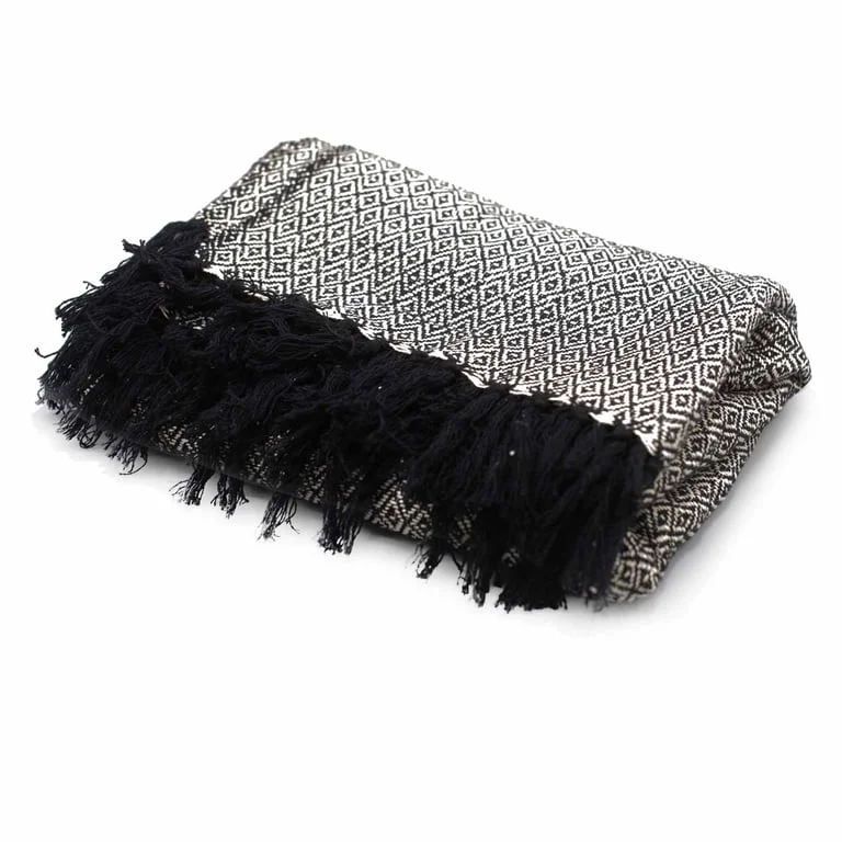 Soft charcoal boho style throw draped over a couch