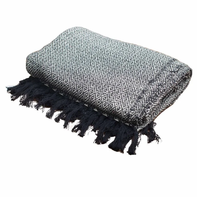 Soft charcoal blanket draped over a wooden chair in a relaxed boho style setting.