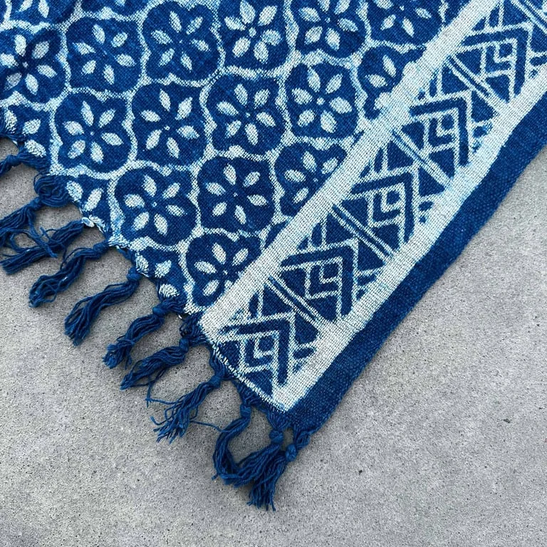 Handmade textile runner in indigo, 170x60cm, woven piece shown hanging on relaxed wooden floor.
