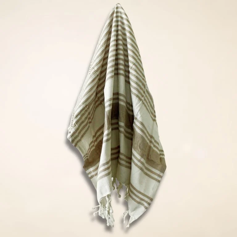 Soft sand coloured towel folded into a neat rectangle, showing its plush texture