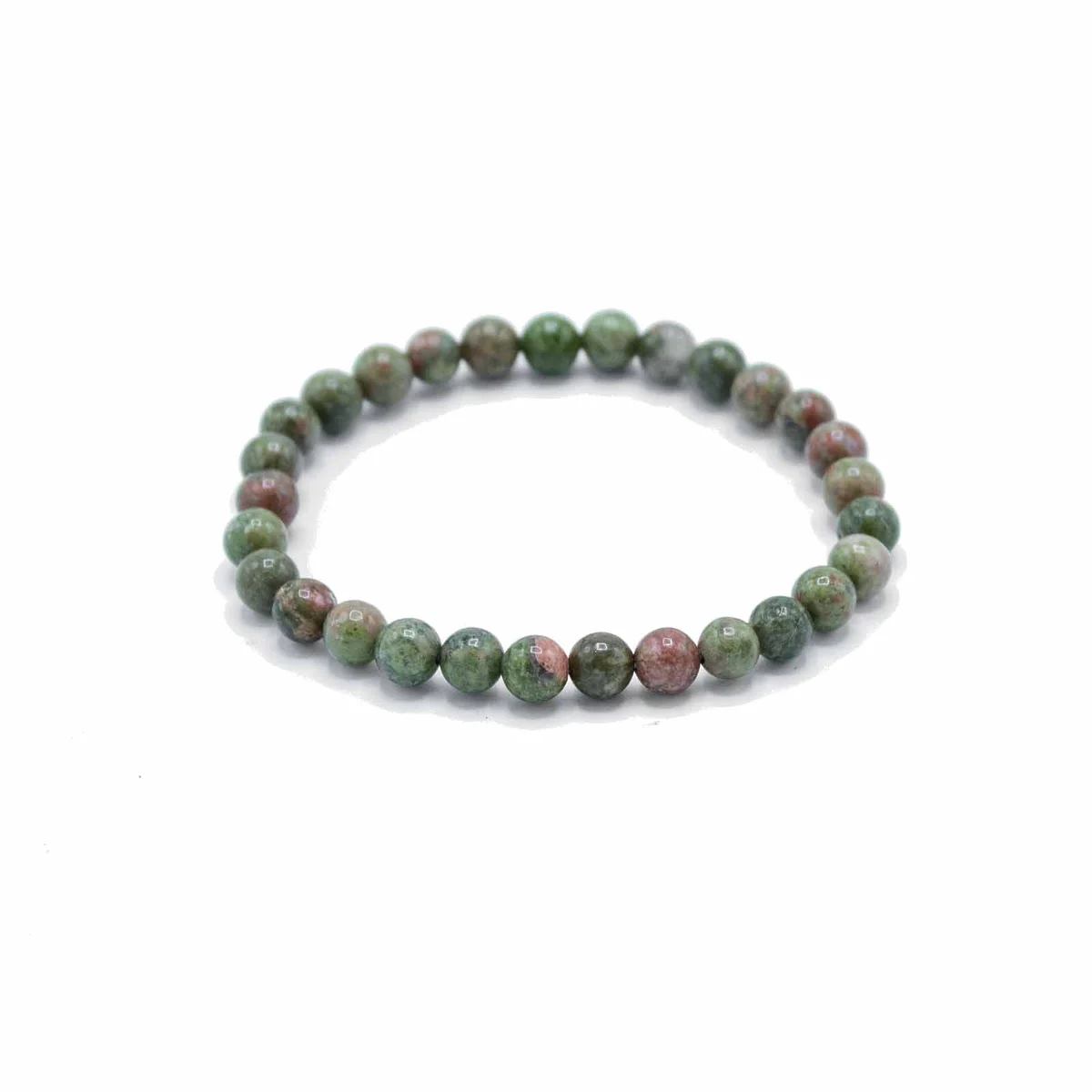 Close-up of green jasper beads on a growth bracelet laid on a white background