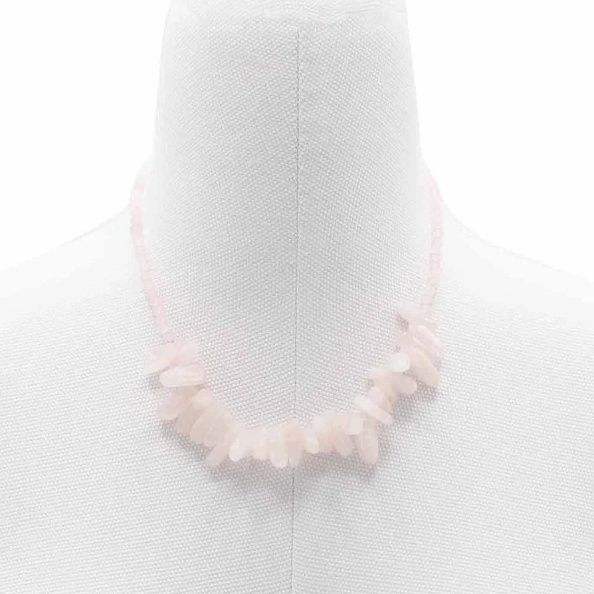 Close-up of a rose quartz gemstone pendant necklace with a longstone cut on a delicate chain