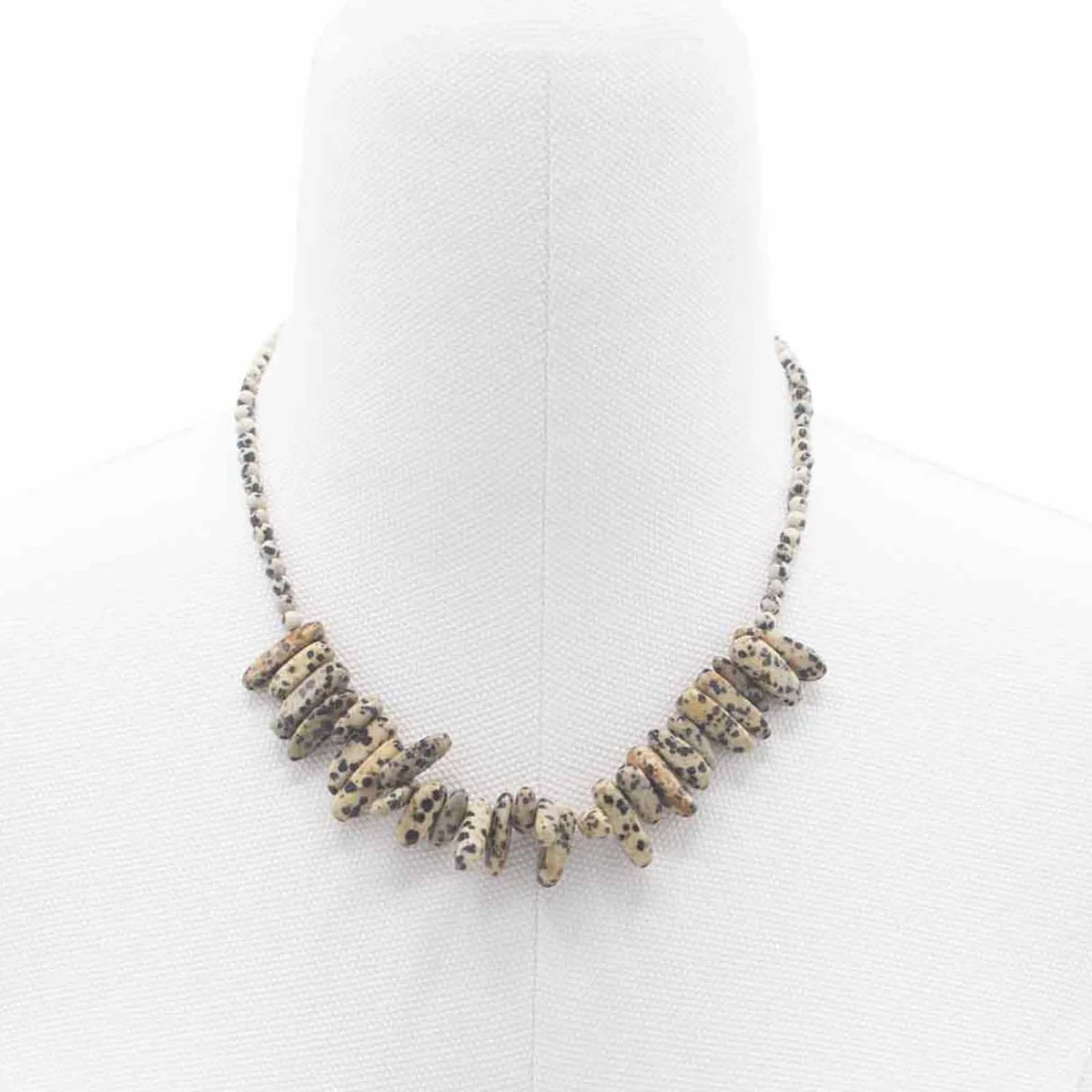 Close-up of Longstone Dalmatian stone necklace with speckled beige and black gemstone pendant on a chain