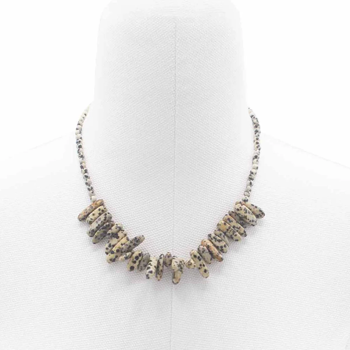 Close-up of Longstone Dalmatian stone gemstone pendant necklace with speckled black and white pattern on chain