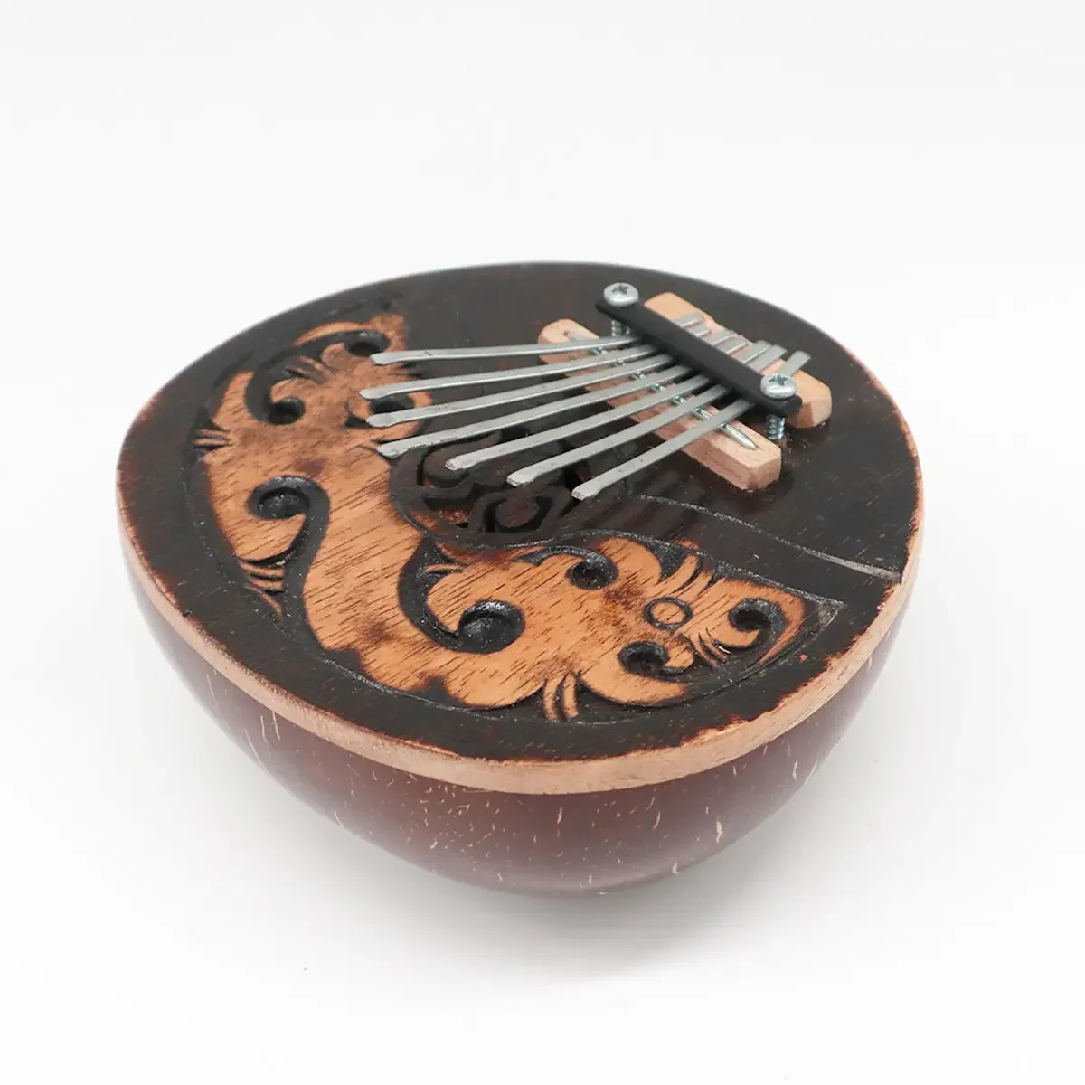 Antique kalimba made from coconut wood with metal tines and wooden resonator body on white background