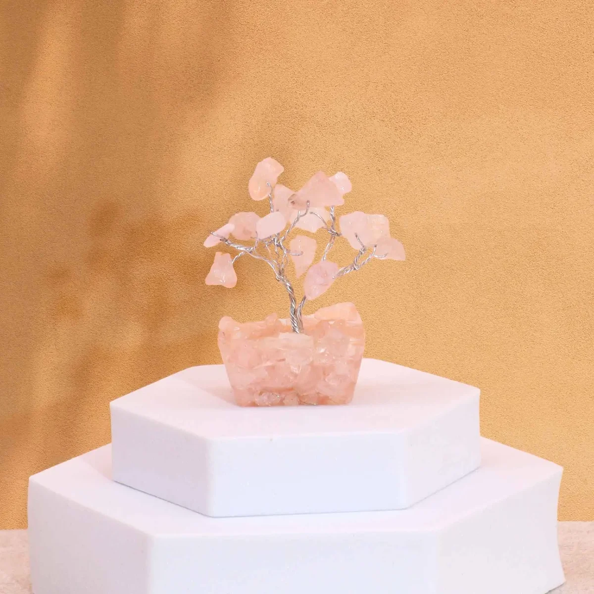 Mini gemstone tree with 15 rose quartz stones on a white orgonite base against a plain background