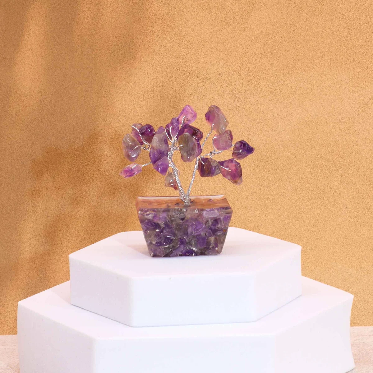 Mini gemstone tree with 15 amethyst stones on a purple orgonite base ornament against a white background