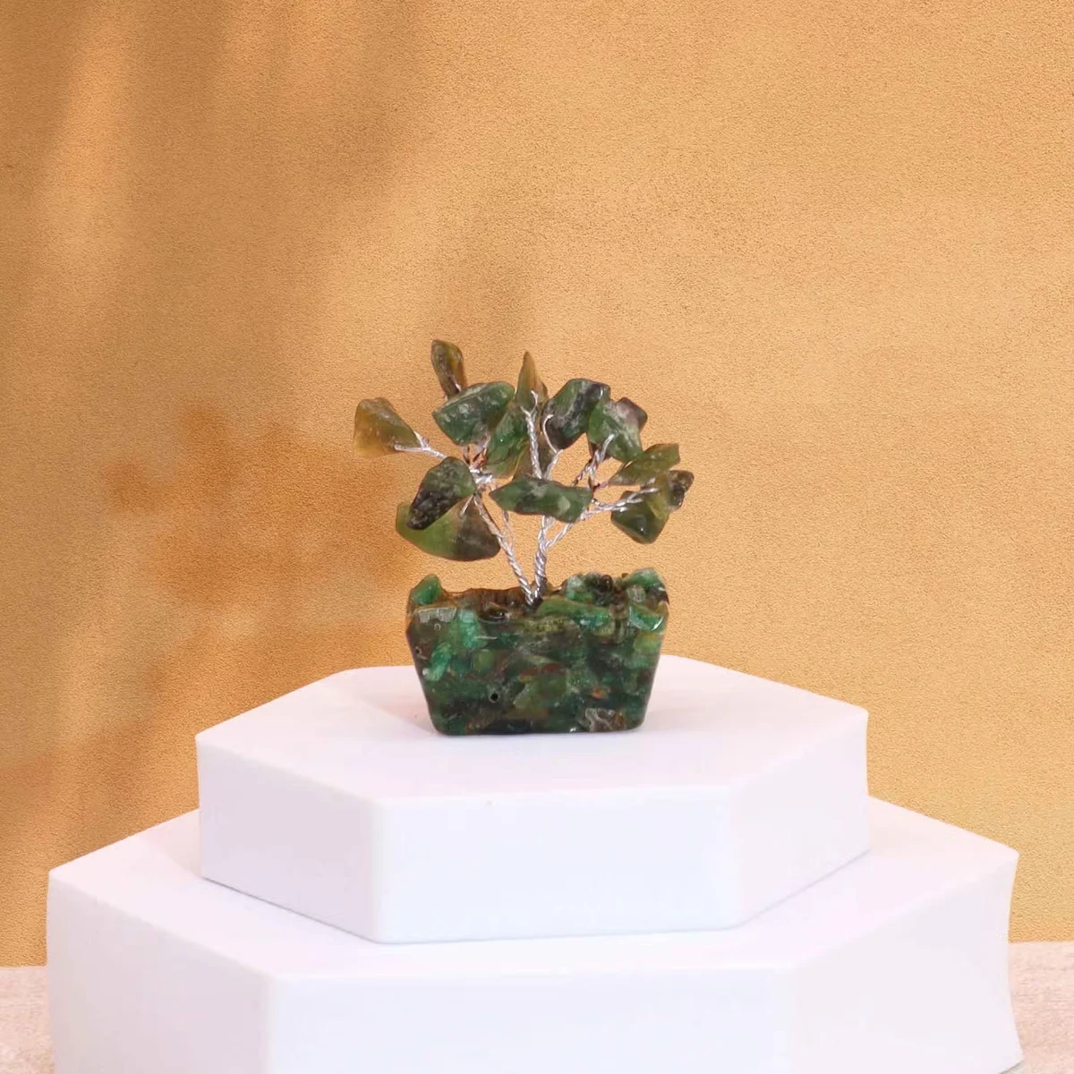 Mini gemstone tree with 15 green aventurine stones on an orgonite base against a white background
