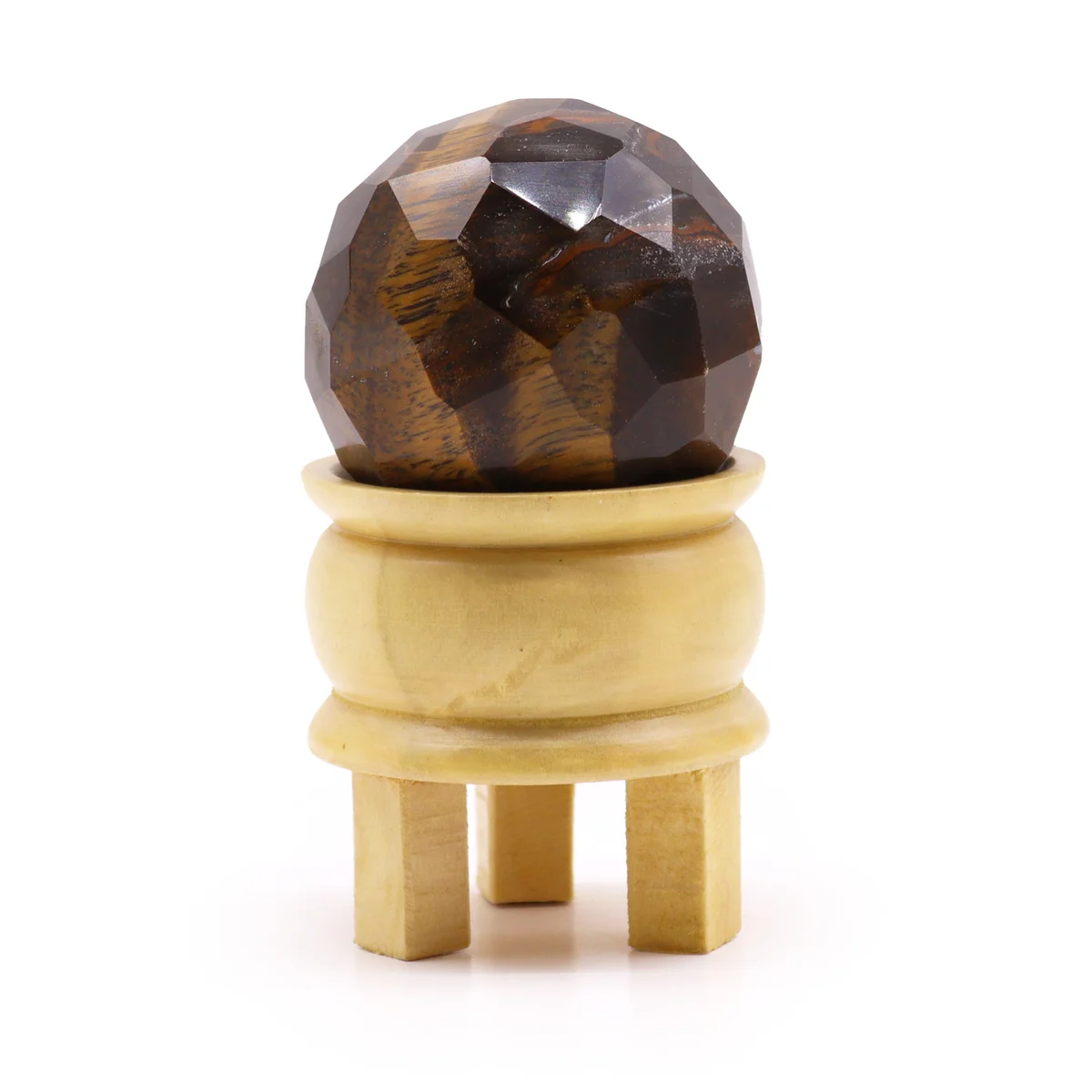 Faceted tigereye gemstone healing crystal ornament ball displayed on a black stand against a white background
