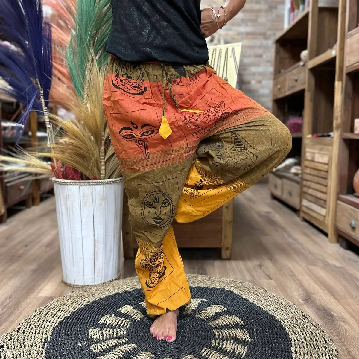 Orange yoga and festival pants featuring a high cross Himalayan print pattern, designed for comfort and style