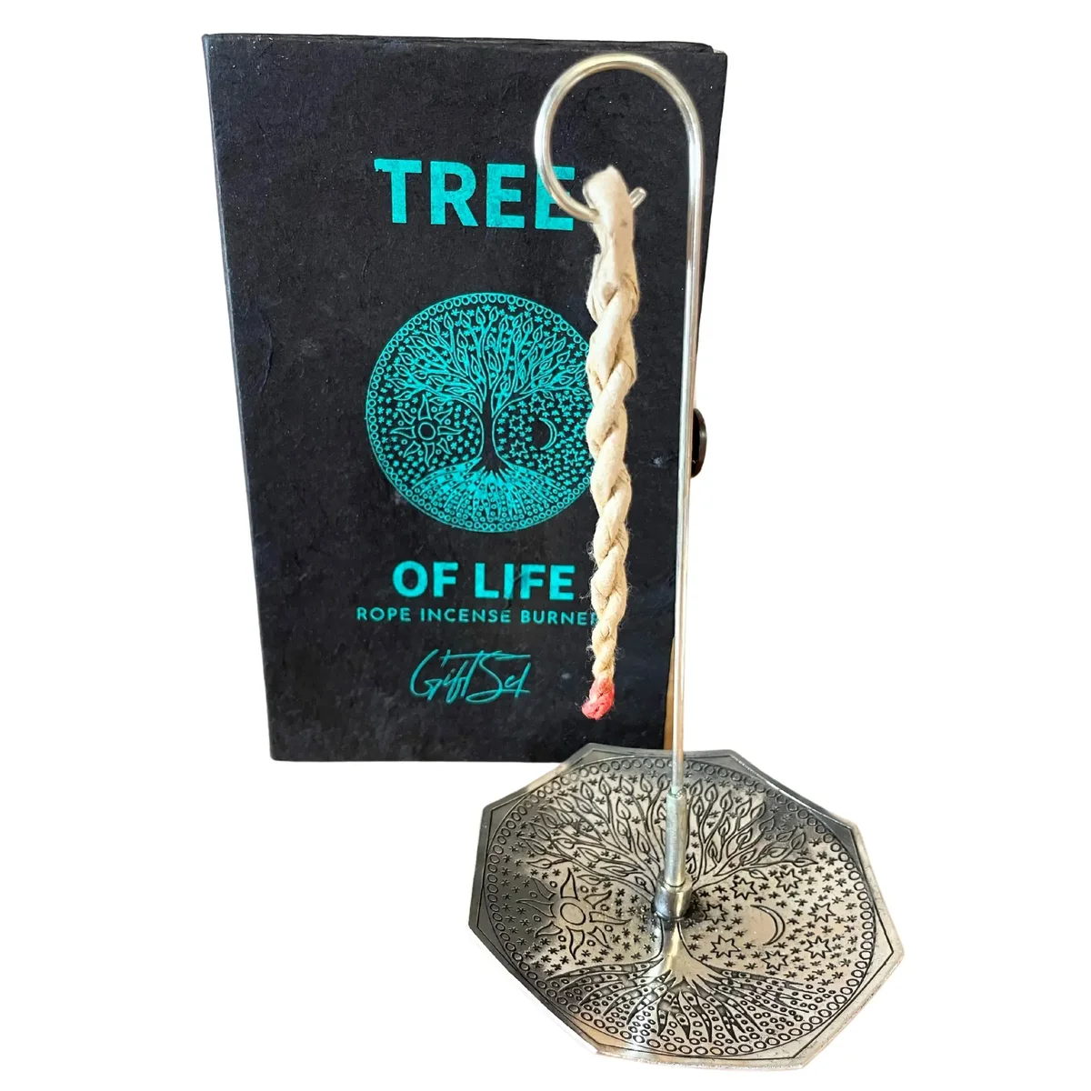 Silver plated incense holder with Tree of Life design alongside rope incense sticks on white background
