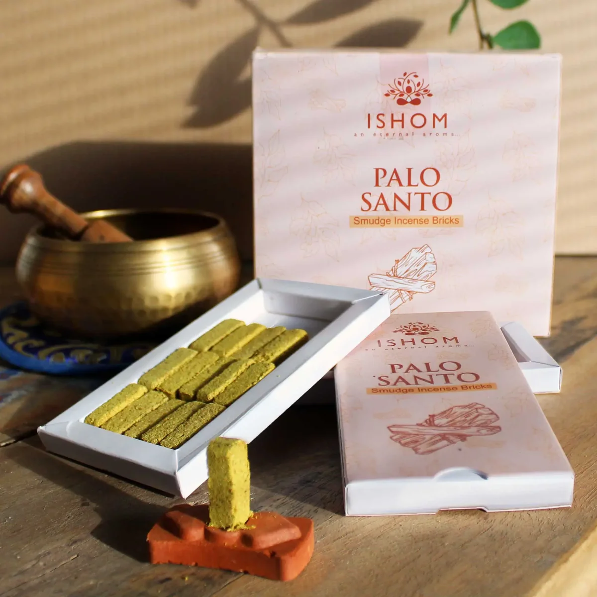 Pack of 15 natural palo santo incense bricks with a wooden burner on a white background