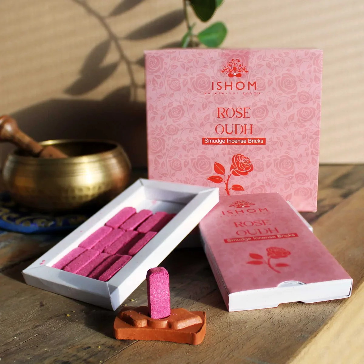 Pack of 15 natural smudge bricks arranged next to a rose wood incense burner on a white background