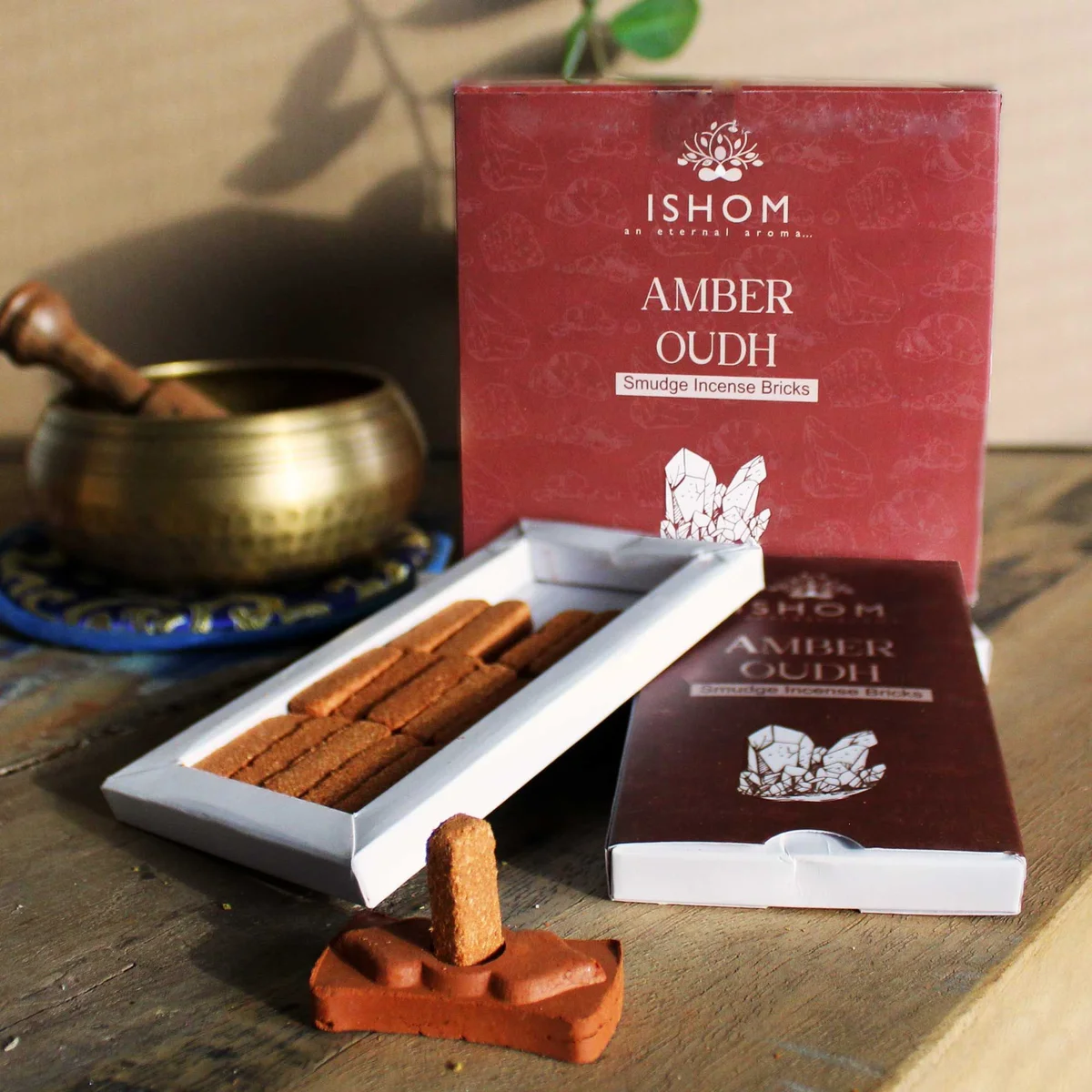 Pack of 15 natural incense smudge bricks arranged with an amber wood burner on a white background