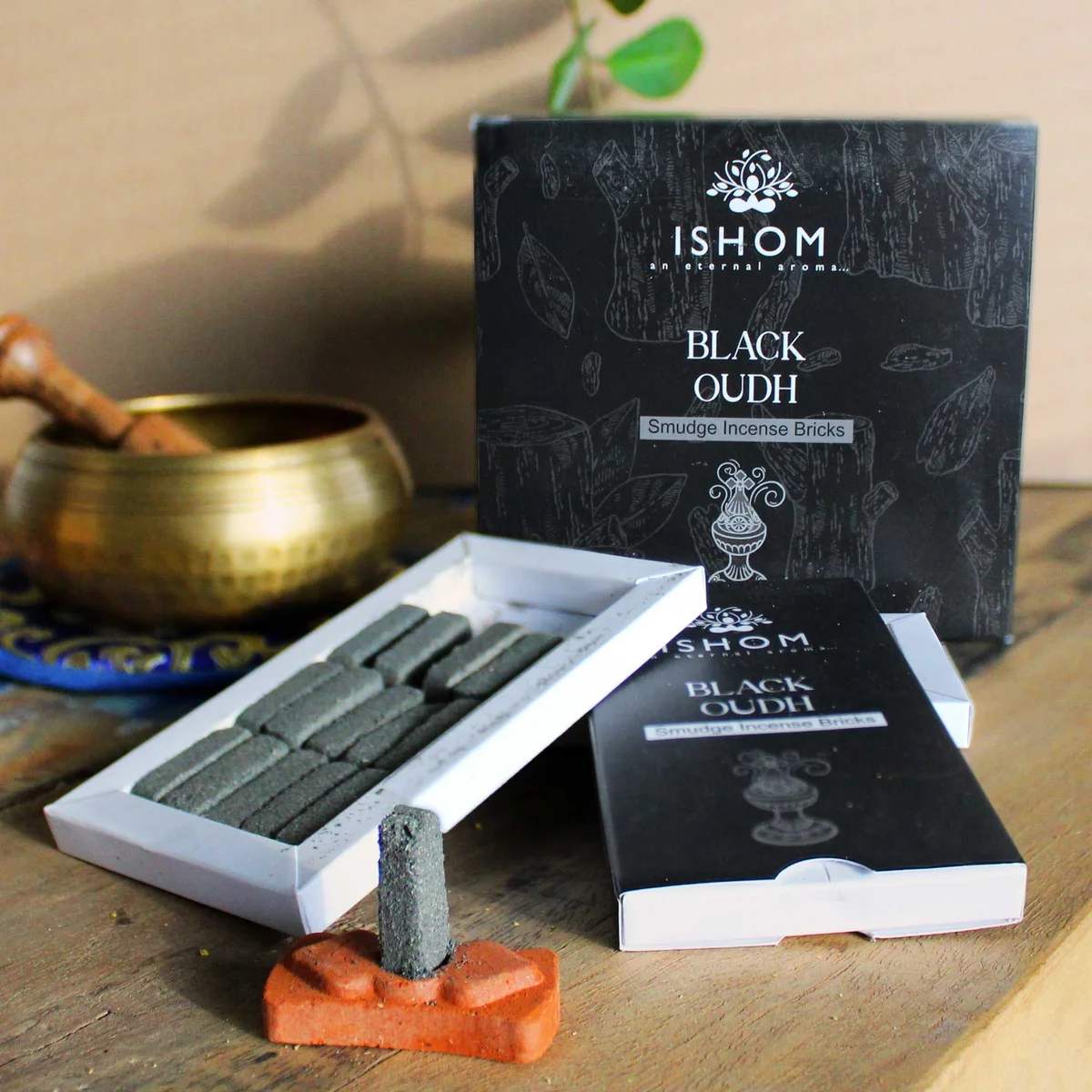 Pack of 15 natural incense smudge bricks arranged with a black wood burner on a white background