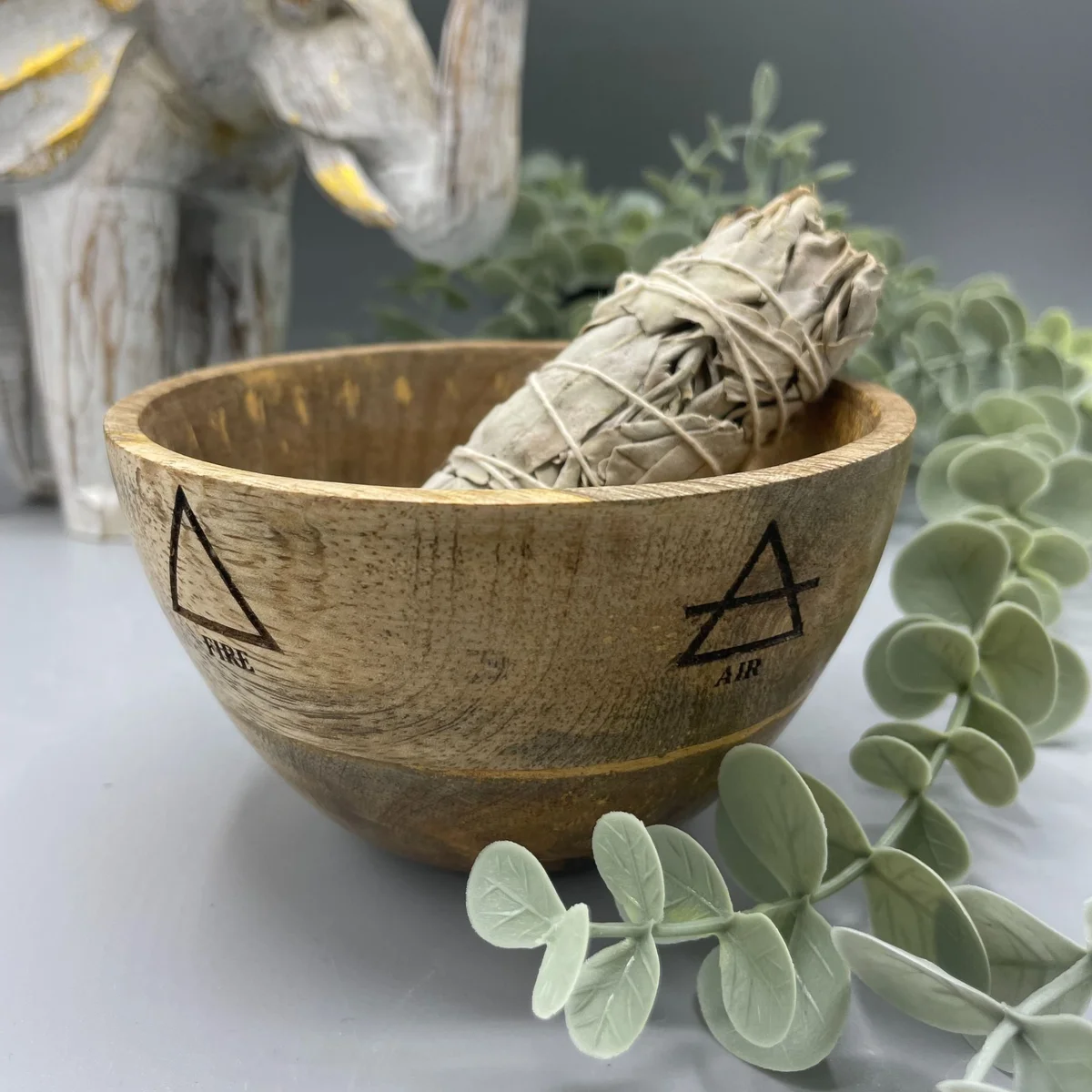 Wooden ritual offerings bowl with four elements design, measuring 11x7cm, shown on a plain background