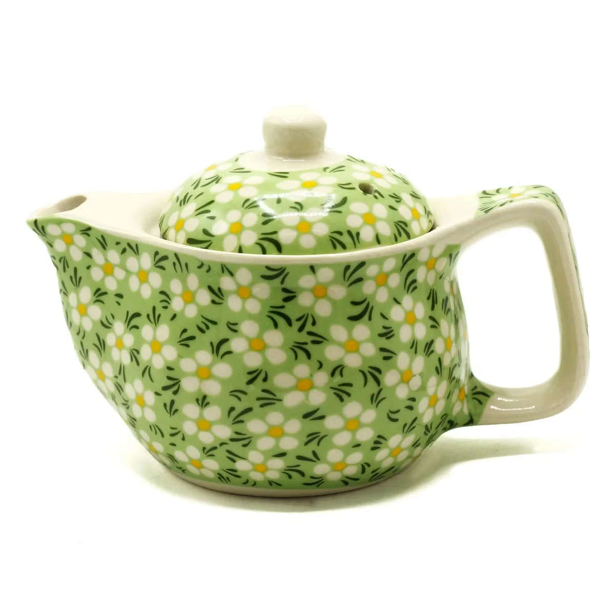 Small tea pot in green daisey finish, beautifully shaped, with a handle and spout, displayed on a stylish white surface