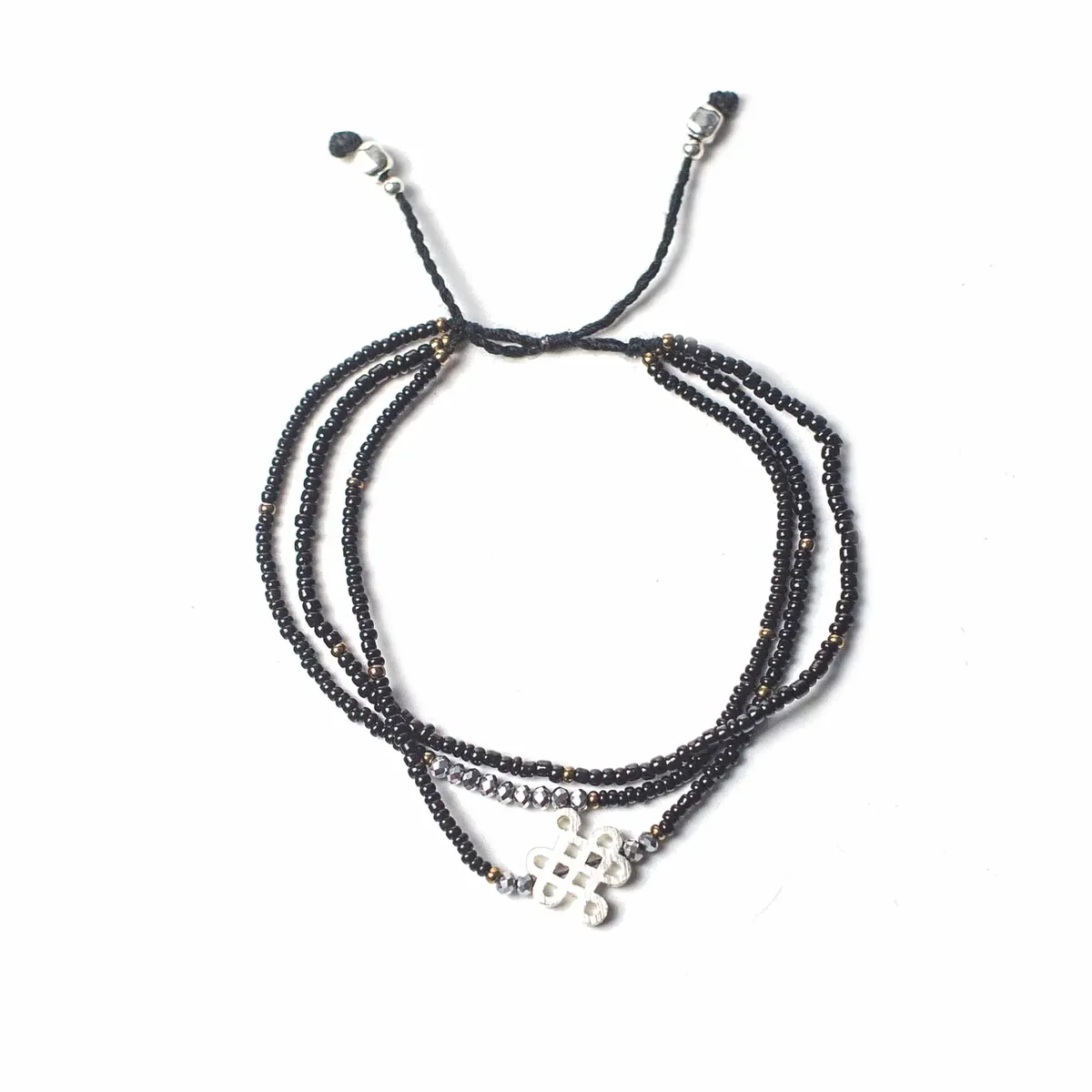 Temple string bracelet hanging on a plain background