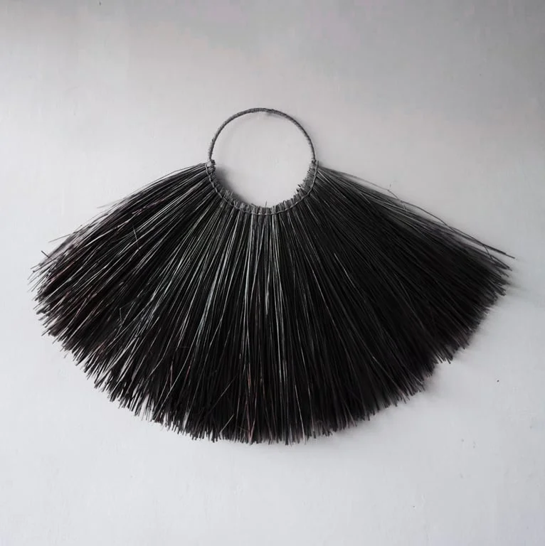 Large seagrass fan wall decor in black, a natural textured wall hanging.