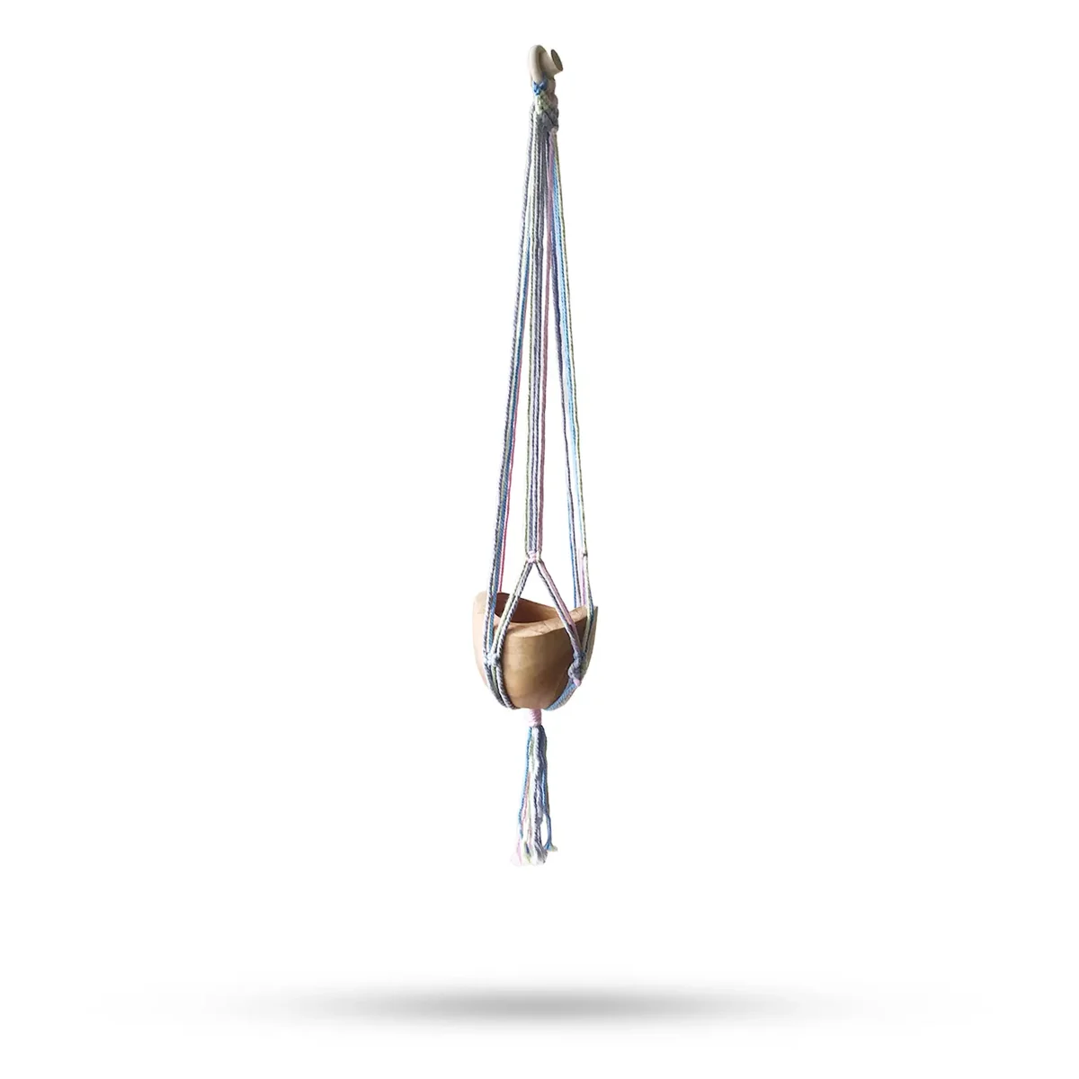 Pastel tones pot holder: macrame design hanging from a wall, holding a medium bathroom pot.