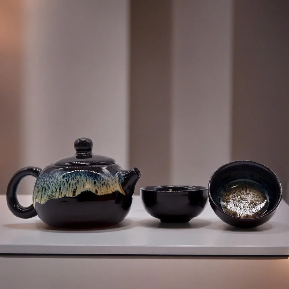 Stylish black glaze teapot set with a matching pot and two cups.