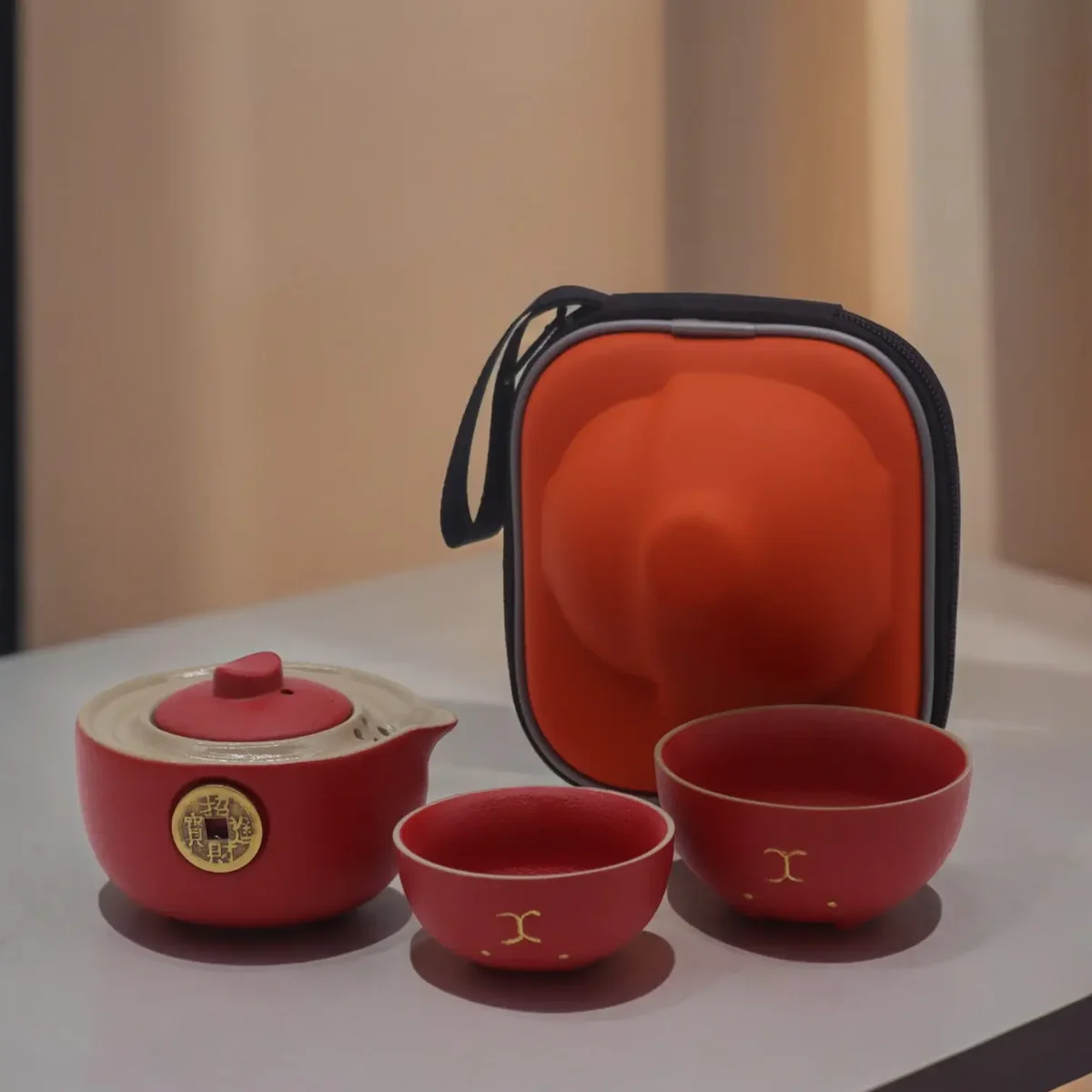 Red travel teapot set featuring a Money Cat design with two matching cups.
