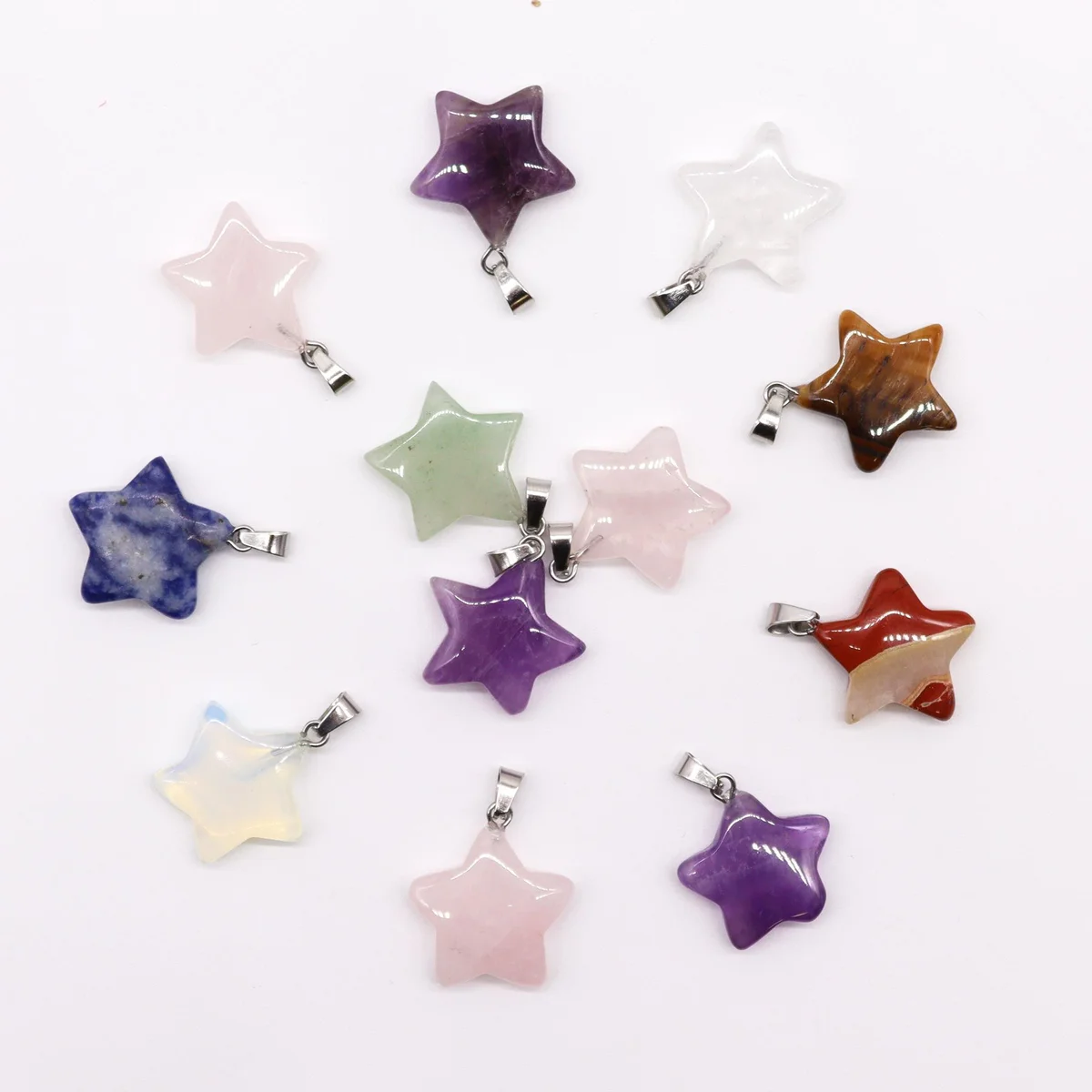 12 assorted 20x6mm gemstone star pendants displayed flat on a neutral surface.