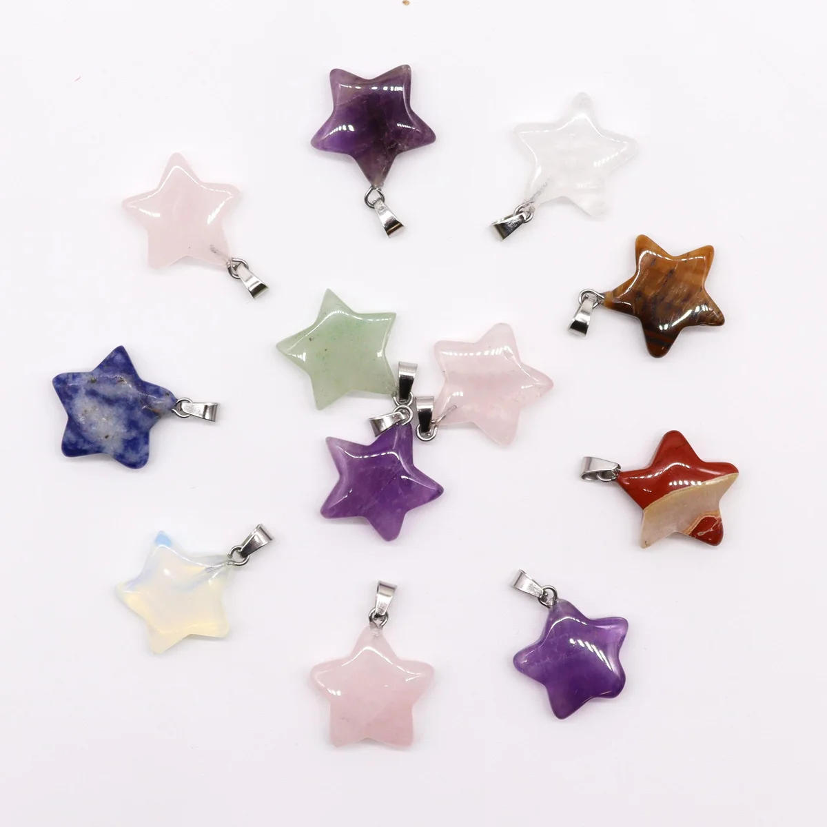 Set of 12 star shaped pendants with assorted gemstones, each 20x6mm, displayed together