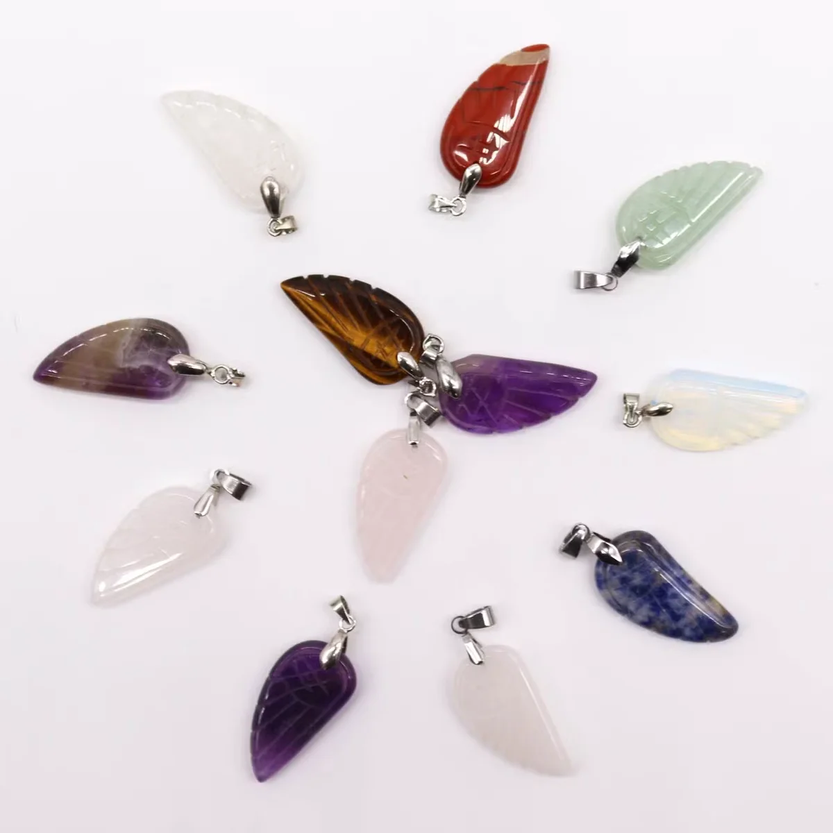 Assorted pendants pack of 12 gemstone angel wings, each 28x15mm, shown clustered in a colourful collection.