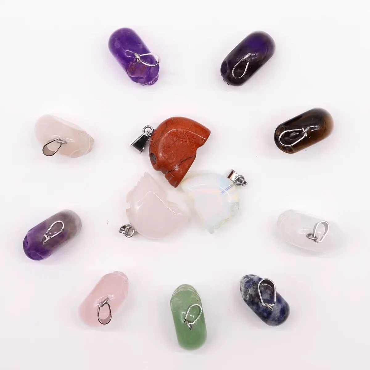 Assorted miniature gemstone skull charms, 20x15mm, displayed as a pendant set, ideal for making skull necklace charms