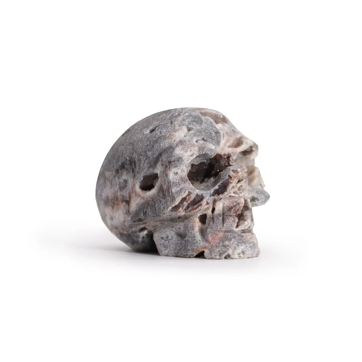 Calcite geode carved skull ornament with translucent white interior and natural geode pattern.
