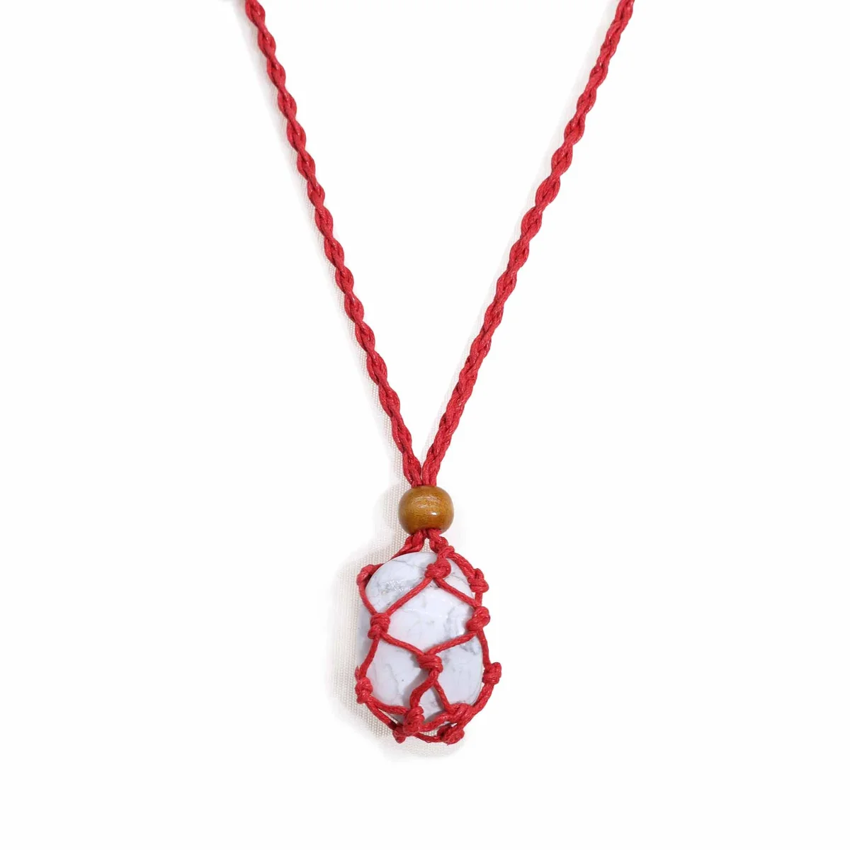 Close-up of a red gemstone necklace cord showing smooth texture and vibrant red color against white background