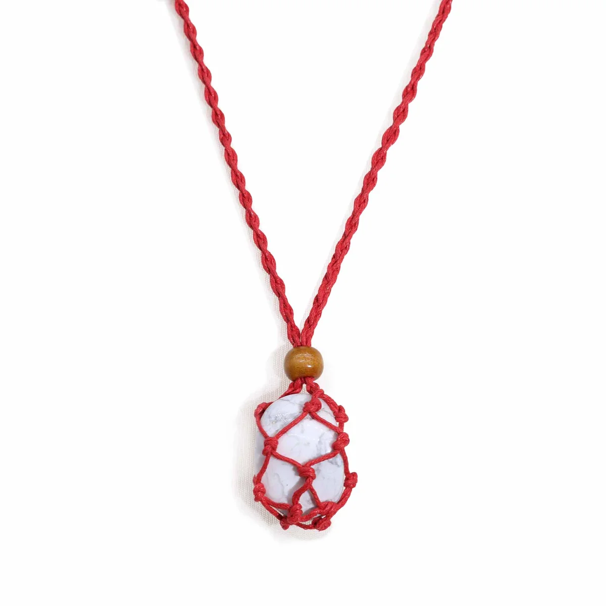 Close-up of a red necklace cord made from gemstone material, showing texture and vibrant color on a white background