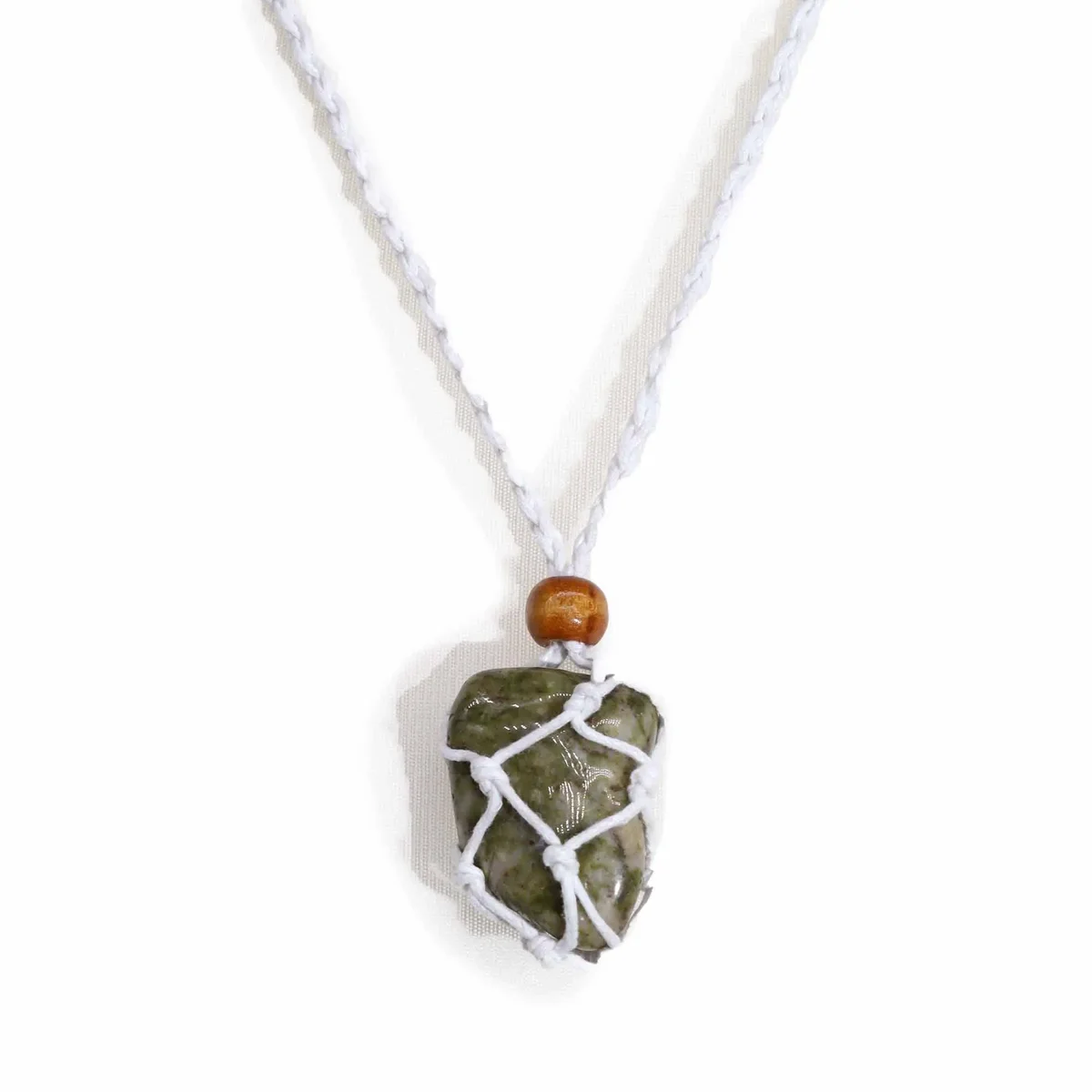 White gemstone necklace cord displayed coiled on a plain background for jewelry making or repair.