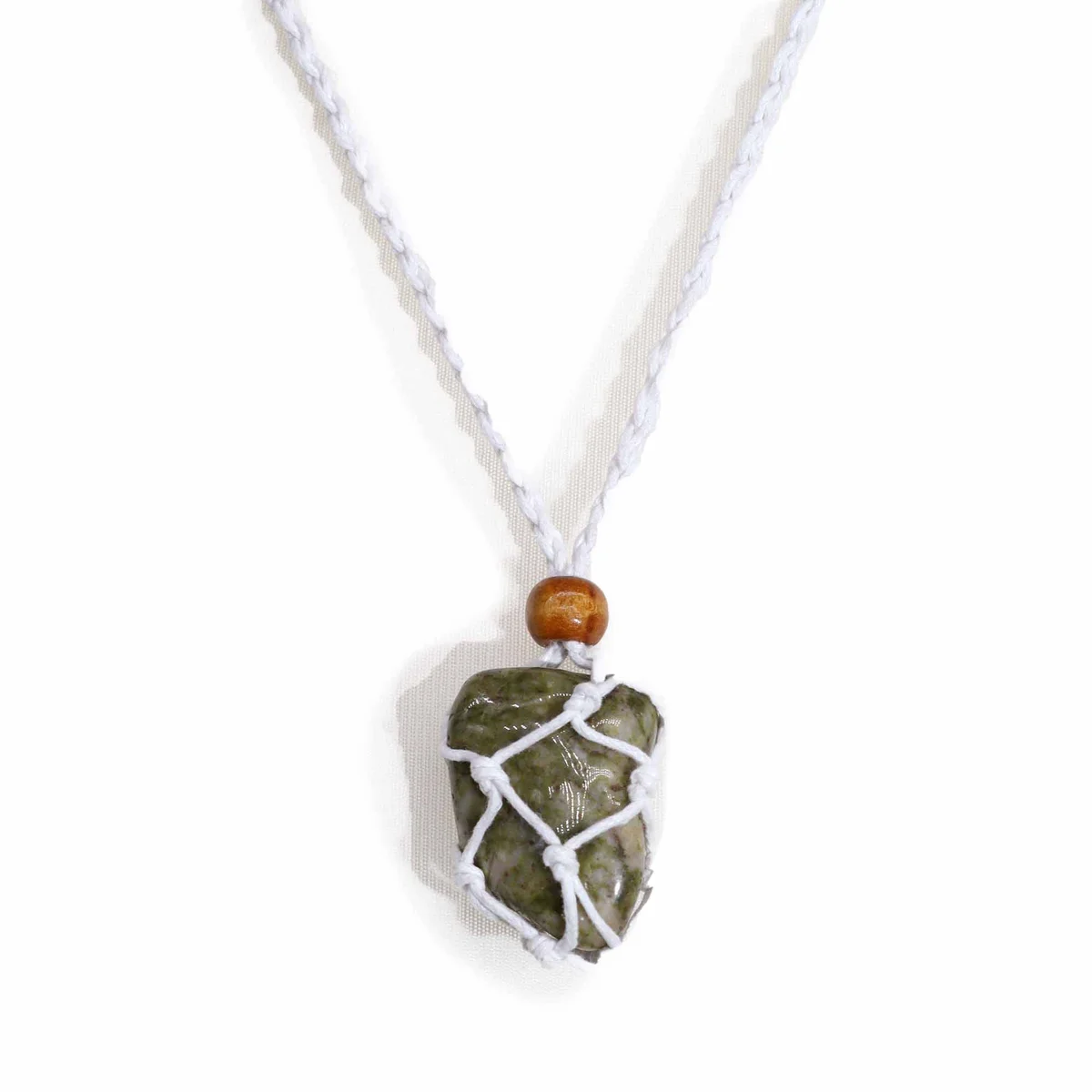 Close-up of a white necklace cord made for gemstone necklaces, showing texture and clasp details on a plain background