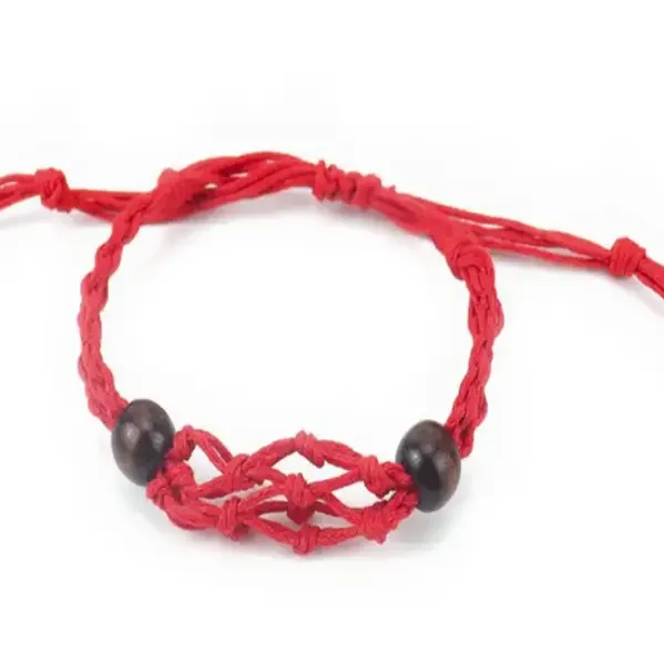 Red gemstone bracelet cord neatly coiled on a white background, showing texture and vibrant color details
