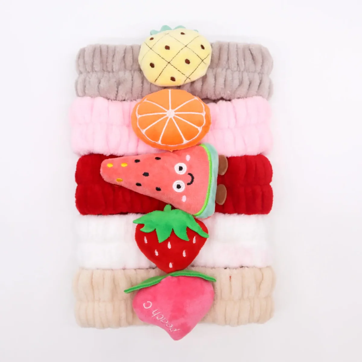 Assorted cute fruity headbands designed for makeup application, featuring bright, playful fruit patterns