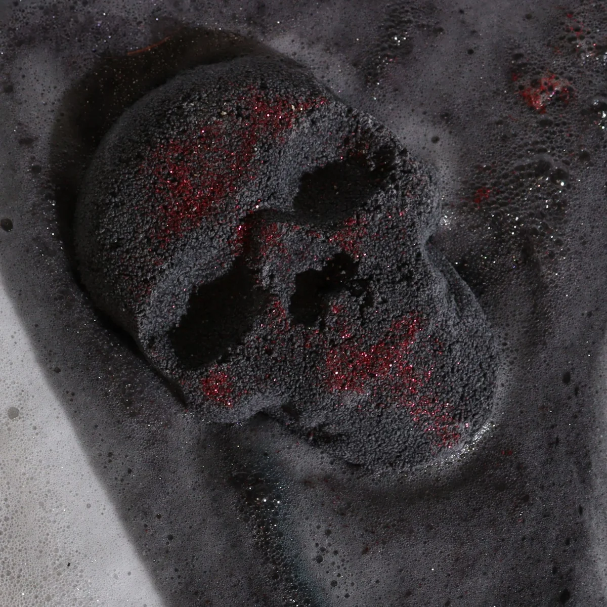 White skull-shaped Halloween bath bomb weighing 40g on a plain background for festive bathing fun