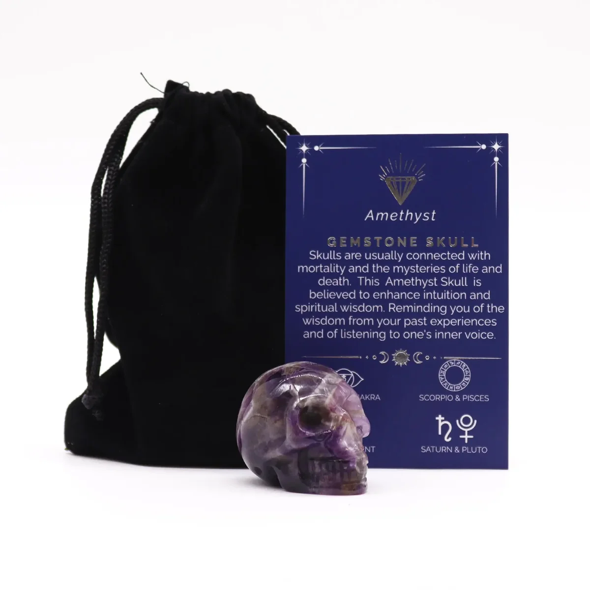 Small gemstone skull carved from purple amethyst displayed on a white background