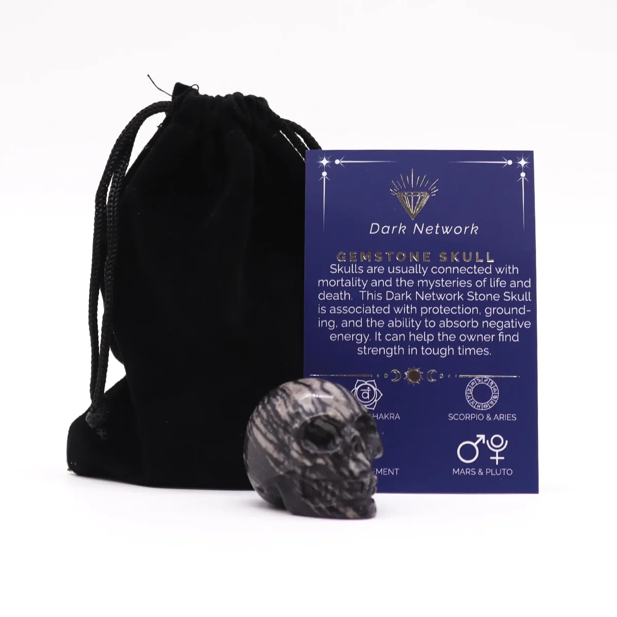 Small dark network stone skull carved from gemstone with intricate natural patterns visible on surface