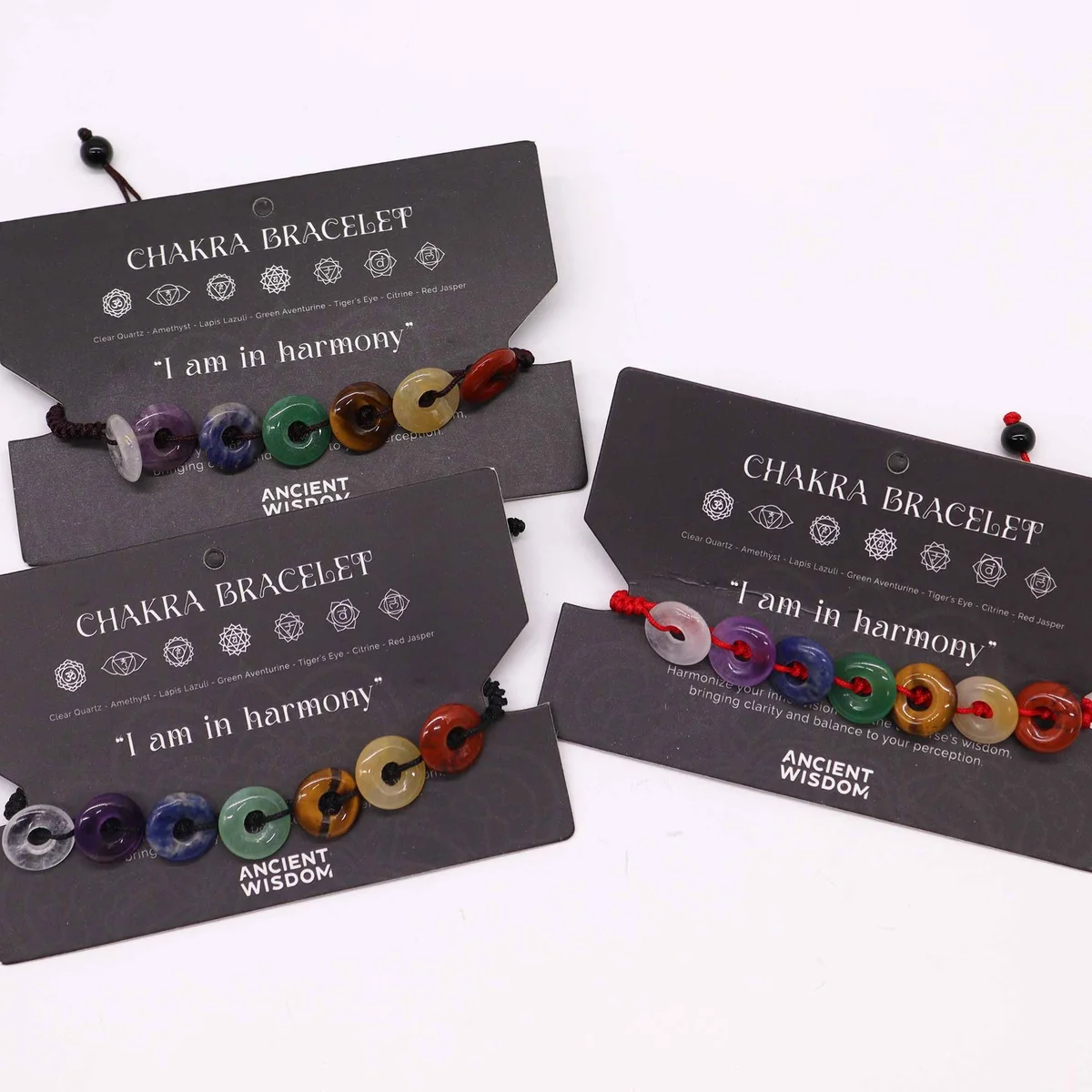 Colourful mini donut beads on a chakra string bracelet laid out on a white background