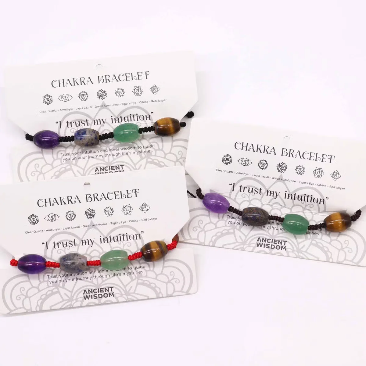 Close-up of chakra jewellery string bracelet with colorful beads arranged in a row on a white background