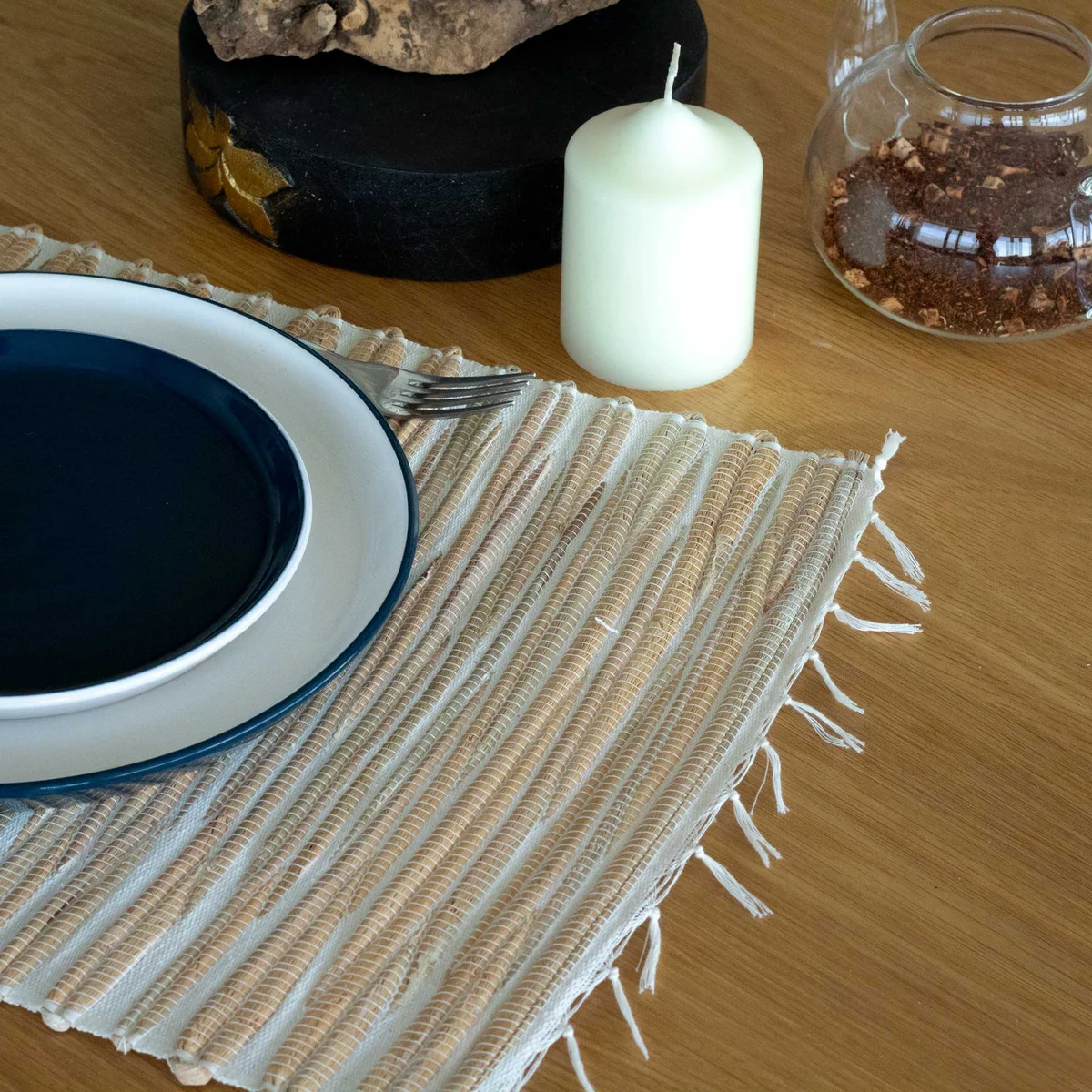 Water hyacinth placemat with natural tiger print and fringe detailing, flat on a white background