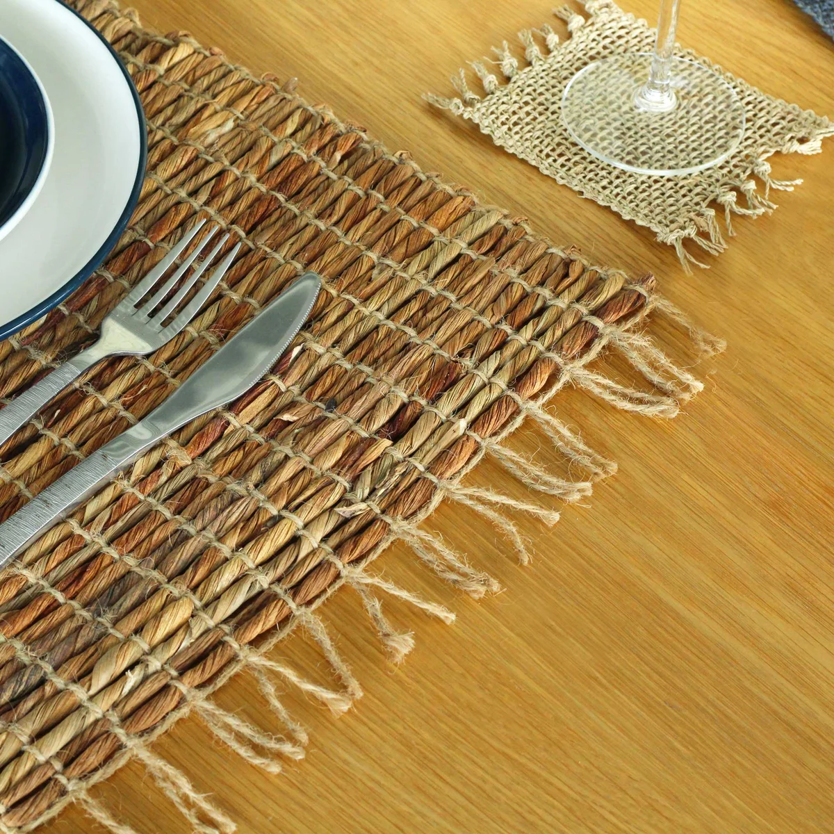 Water Hyacinth robusta fringe placemat with natural woven texture and decorative fringed edges on a white background